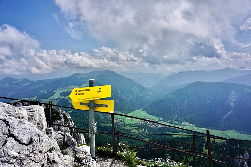 Signs of walking paths. Signs for hiking in Bavaria. Direction signs in the mountains. Mountain direction signs for tourists. Direction signs. Yellow direction signs for tourists.