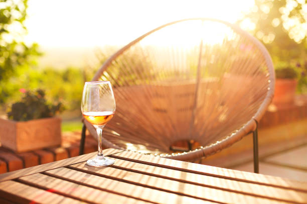 Wineglass on brick border in yard High angle of glass of wine placed on brick barrier on sunny summer day in yard crystal chalice stock pictures, royalty-free photos & images