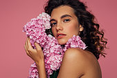 Beautiful emotional woman holding bouquet of flowers