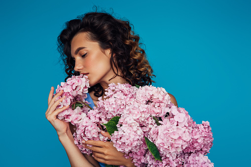 Beautiful emotional woman holding bouquet of flowers