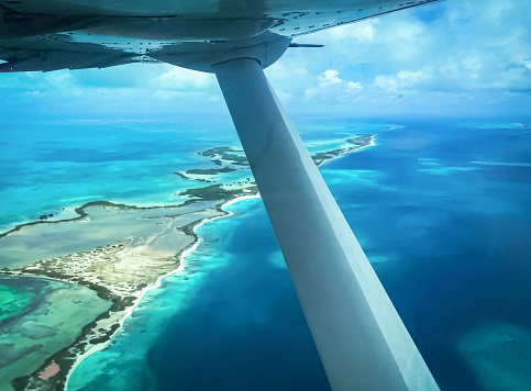 Aerial view of Los Roques archipelago with its coral reefs and turquoise waters in Venezuela. Coral reefs and turquoise waters from a plane.