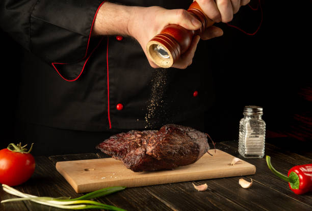 istock The chef sprinkles the baked beef meat with pepper. Working environment on the kitchen table. Asian cuisine 1469503125