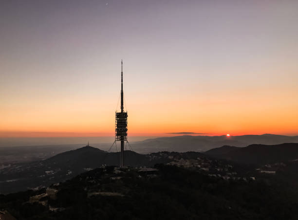 View of Collserola Tower on Tibidabo mountain during sunset. Television tower antenna over a mountain in Barcelona, Spain