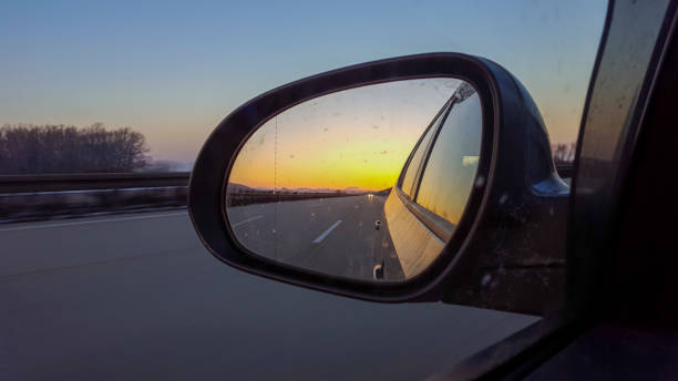 istock Winter sunset in car exterior mirror while driving 1469504447