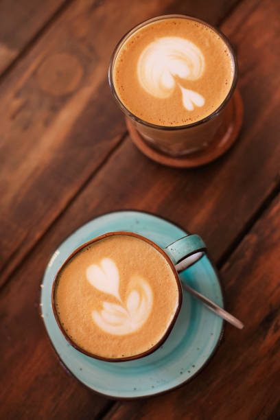 istock Mugs with latte on wooden table 1469506650