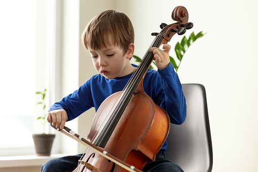White 5 year old boy learning to play the cello
