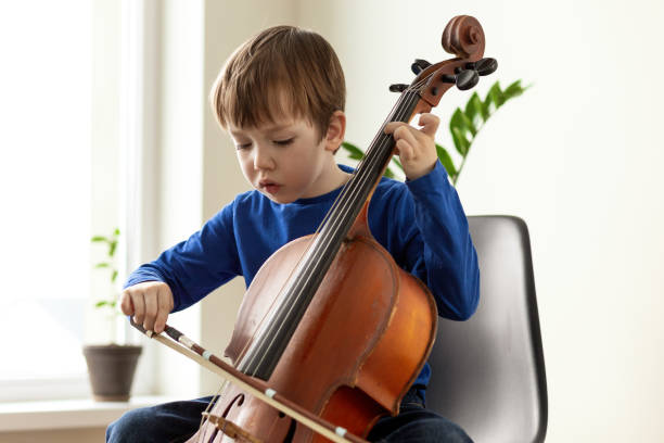 White 5 year old boy learning to play the cello White 5 year old boy learning to play the cello string instrument stock pictures, royalty-free photos & images