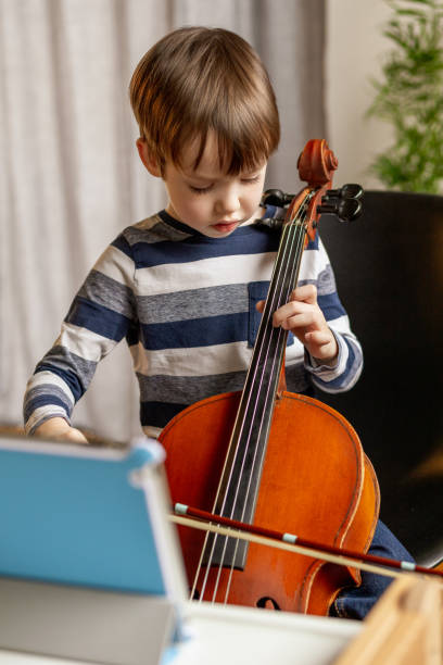 istock A white 5 year old boy is learning to play the cello. uses digital tablet 1469507731