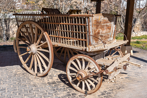 Old weathered wagon in a rural setting against a cloudy sky background.