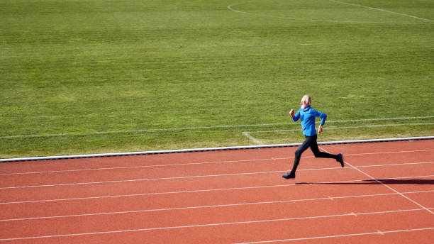 Confident senior athlete running at the sports stadium stock photo