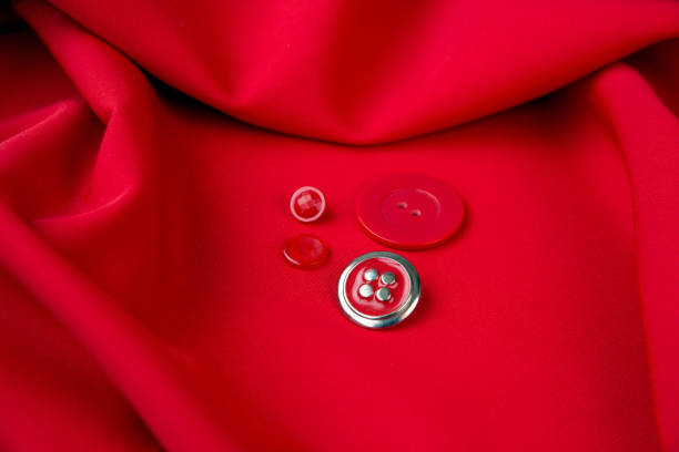 background of red fabric and red buttons lying on it. the texture of the fabric. - article textile material new imagens e fotografias de stock