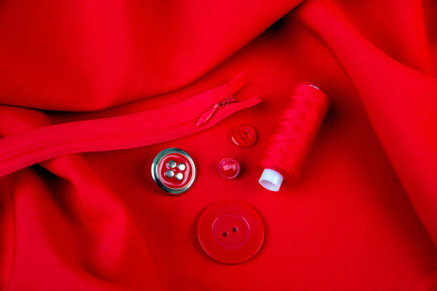 background of red fabric, threads, buttons, zipper. the texture of the fabric. - article textile material new imagens e fotografias de stock