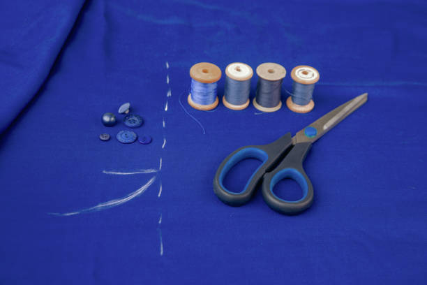 blue fabric with chalk marks, scissors, threads, buttons. the texture of the fabric. - article textile material new imagens e fotografias de stock