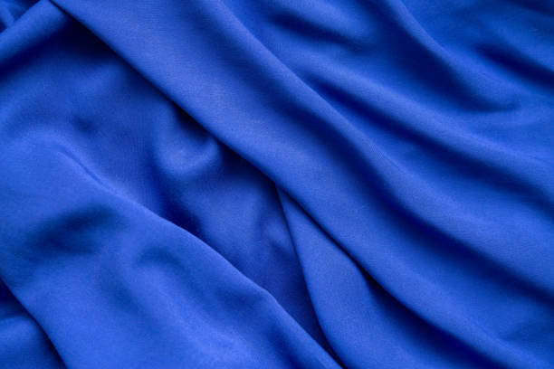 background from blue fabric in folds. the texture of the fabric. - article textile material new imagens e fotografias de stock