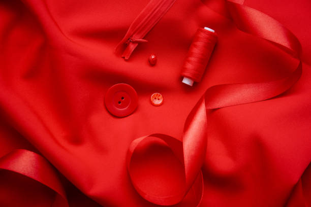 background of red fabric, threads, buttons, zipper. the texture of the fabric. - article textile material new imagens e fotografias de stock