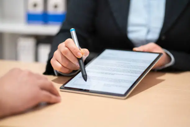 Photo of signing a contract on a digital tablet