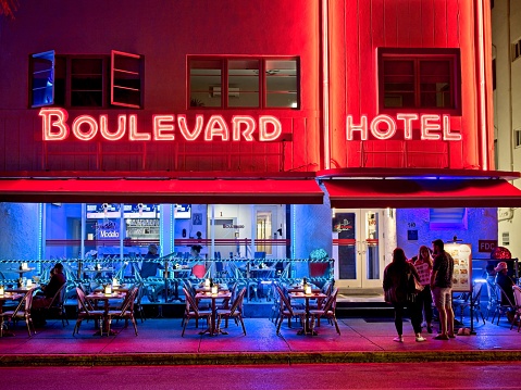 Miami Beach, FL - USA, February 1, 2023. Bright neon lights of the Boulevard Hotel and sidewalk cafe along Ocean drive, Miami Beach Florida.