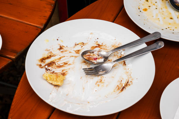 istock white plate and fork with leftover food on the table 1469519510
