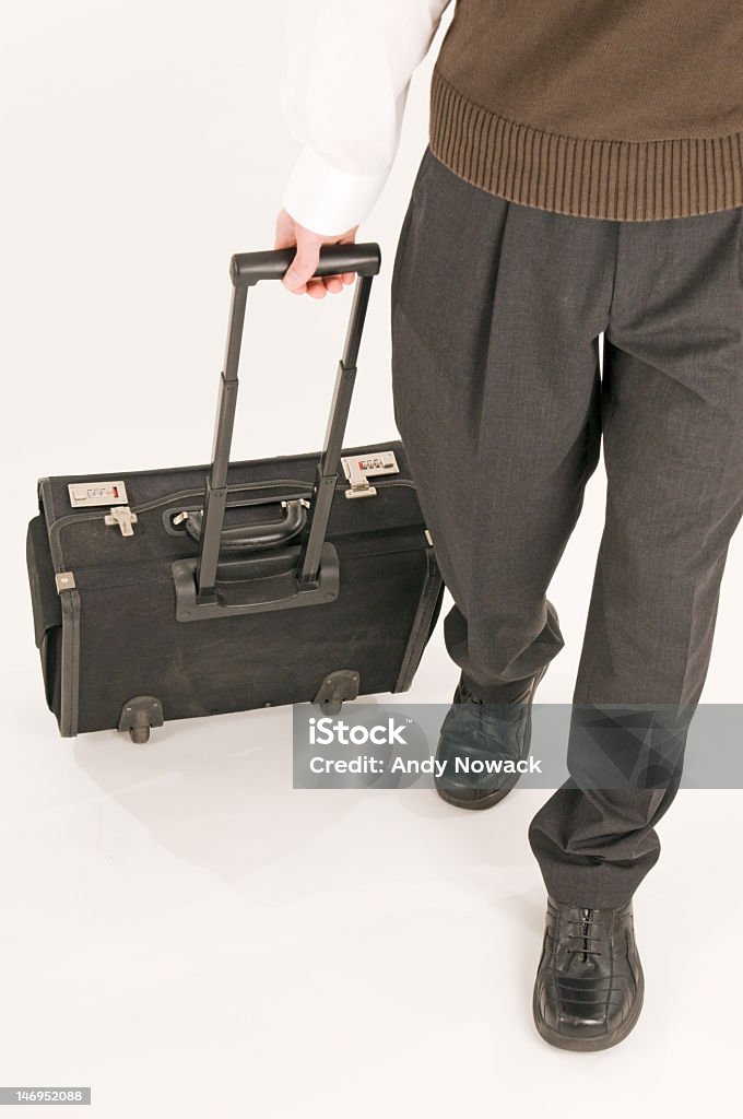Walking with suitcase in front Unrecognizable man in black pants walking with the black suitcase; front Activity Stock Photo