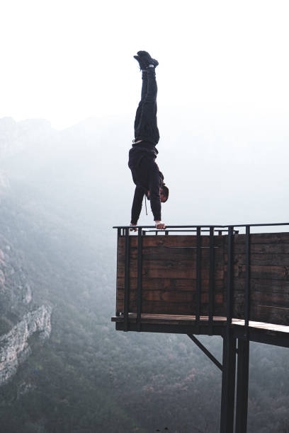 istock Man doing a handstand on high viewpoint on mountain railing edge 1469522412