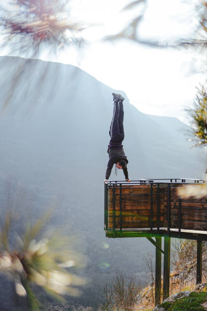 istock Man doing a handstand on high viewpoint on mountain railing edge 1469522422