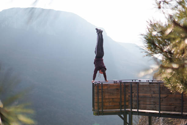 istock Man doing a handstand on high viewpoint on mountain railing edge 1469522424