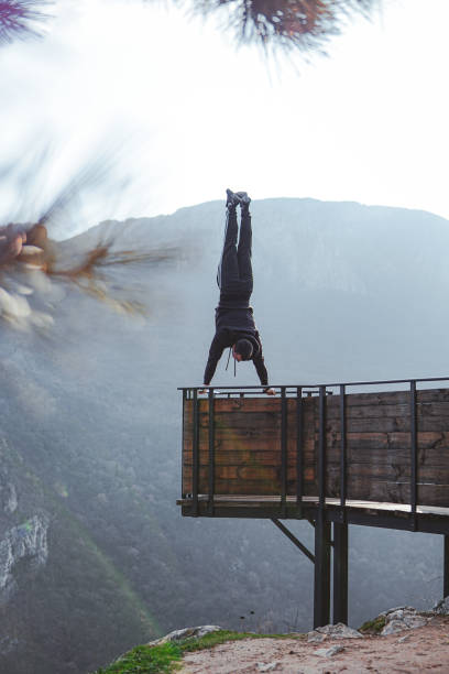 istock Man doing a handstand on high viewpoint on mountain railing edge 1469522428