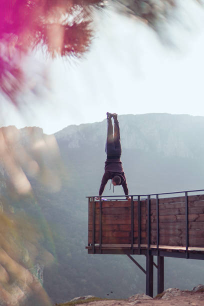 istock Man doing a handstand on high viewpoint on mountain railing edge 1469522429