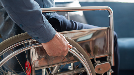 Close-up Man in wheelchair holding wheel
