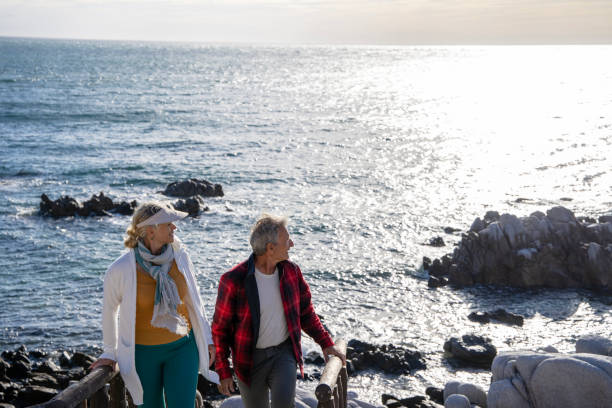 istock Mature couple ascend steps from rocky beach point 1469526482