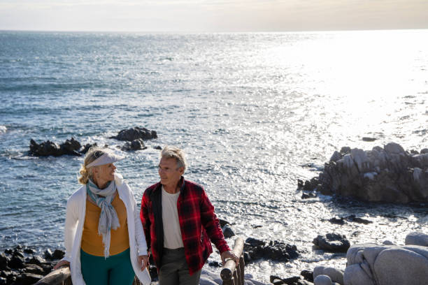 istock Mature couple ascend steps from rocky beach point 1469526559