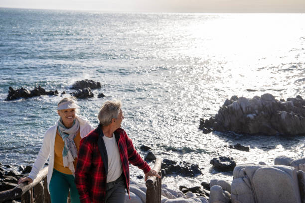 istock Mature couple ascend steps from rocky beach point 1469526564