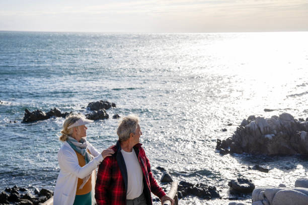 istock Mature couple ascend steps from rocky beach point 1469526566