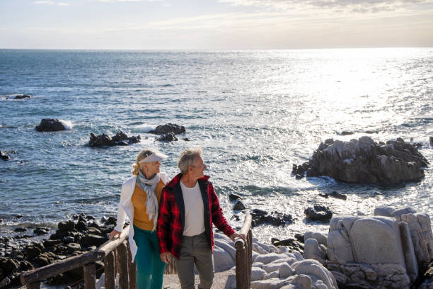 istock Mature couple ascend steps from rocky beach point 1469526618