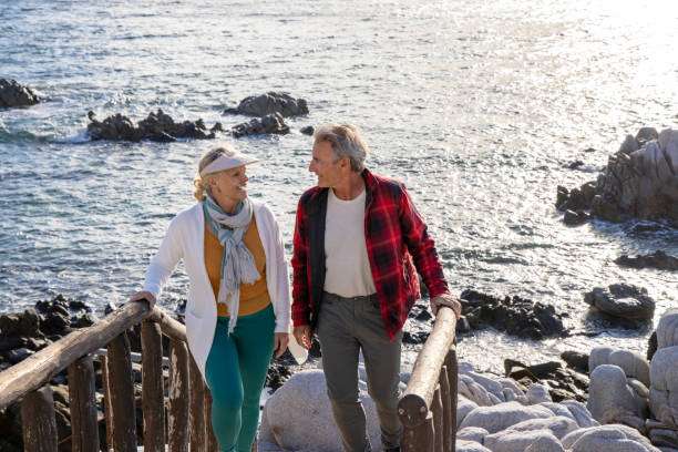 istock Mature couple ascend steps from rocky beach point 1469526731
