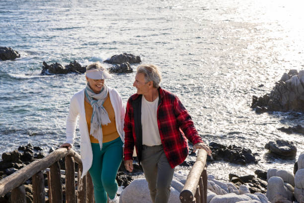 istock Mature couple ascend steps from rocky beach point 1469526737