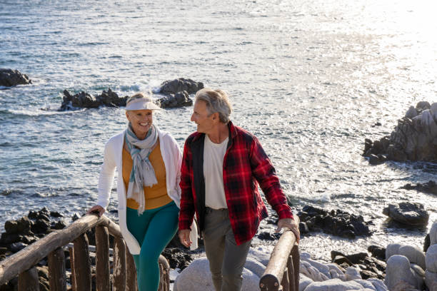 istock Mature couple ascend steps from rocky beach point 1469526773