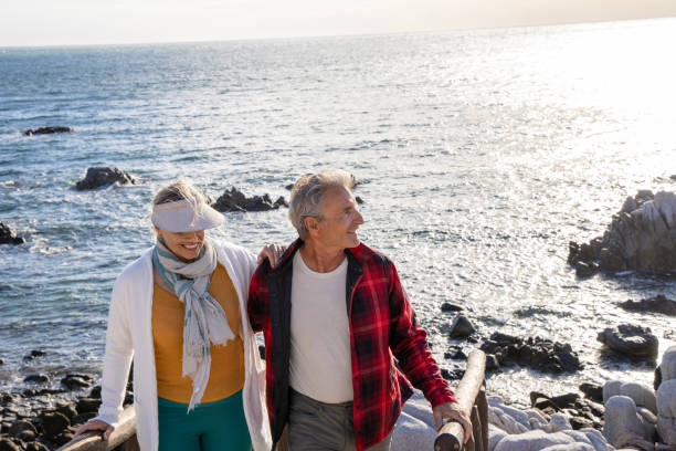 istock Mature couple ascend steps from rocky beach point 1469526777