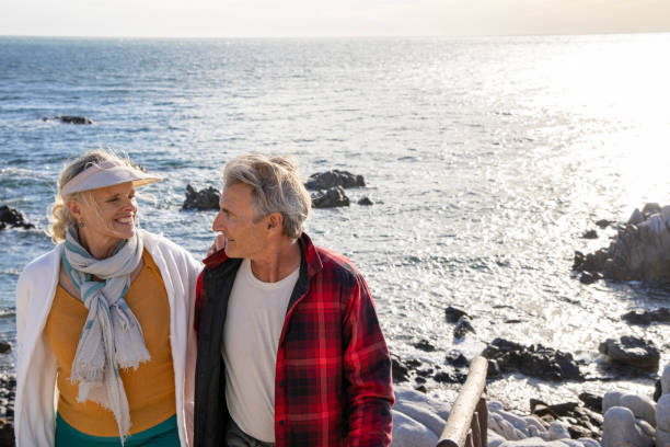 istock Mature couple ascend steps from rocky beach point 1469526806