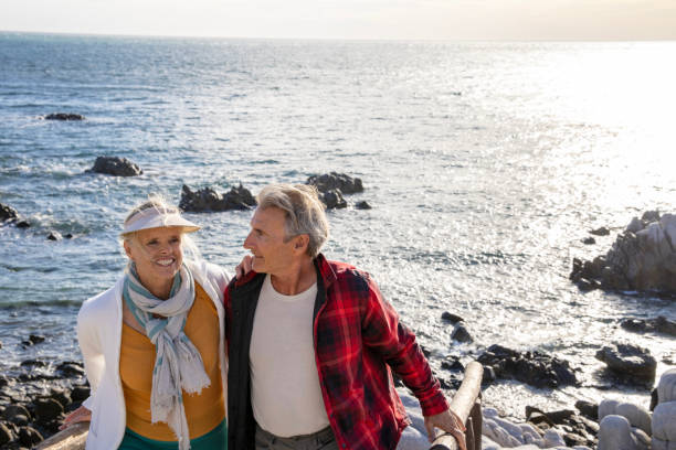 istock Mature couple ascend steps from rocky beach point 1469526813