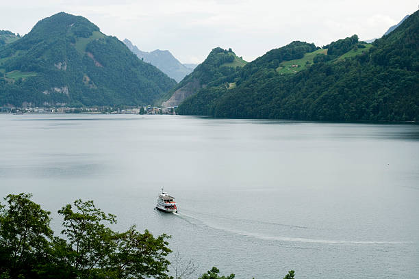 Ferry boat on a lake with mountains around stock photo