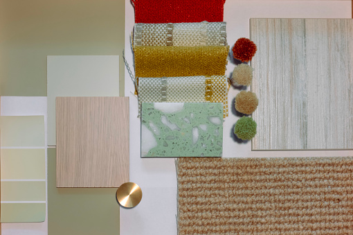 Texture and material samples for interior design projects, such as rugs, wallpaper, fabric and tiles, laid out to illustrate a modern colorful home styling scheme by interior architect and designer