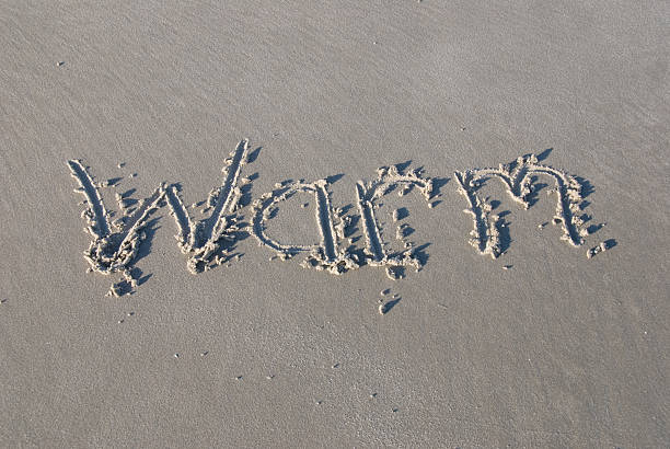 &quot;Warm&quot; written in sand stock photo