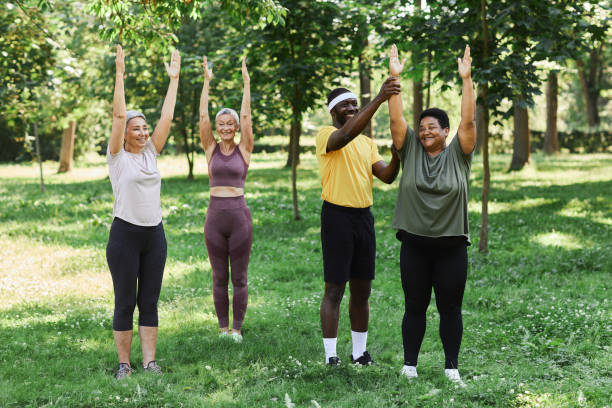 istock Seniors working out outdoors in park with coach and smiling happily 1469533702