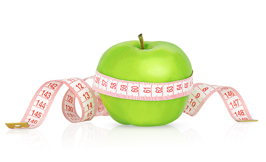 Green apple with measuring tape isolated on white background. Weight loss and dieting concept