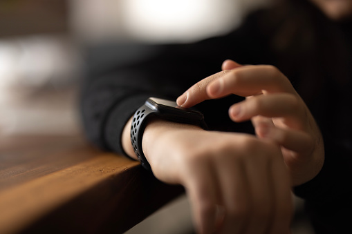 Close up of hand touching smartwatch with health app on the screen, gadget for fitness active lifestyle.