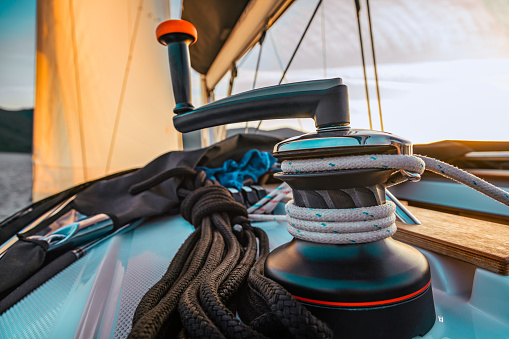 Handle and winch on sailboat at sunset.