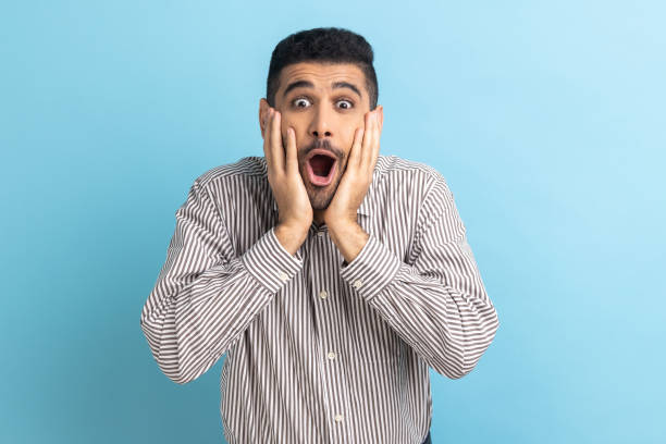 istock Surprised bearded businessman standing with open mouth and keeps hands on cheek, being impressed. 1469544792