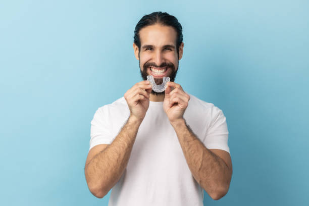 Man using teeth whitening braces, dental aligner retainer, dental clinic for beautiful teeth. stock photo
