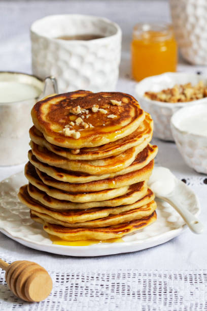istock Apple pancakes served with honey, sour cream, nuts, tea and coffee. 1469549883